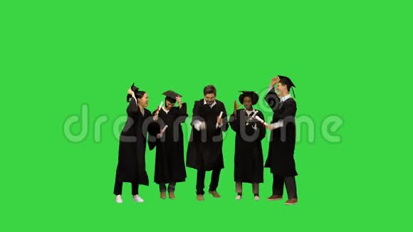 毕业帽被一群快乐的学生朋友扔在绿色屏幕上铬键视频的预览图