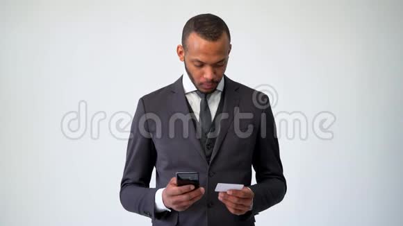 专业的非裔美国人商人用手机说话持有银行信用卡视频的预览图