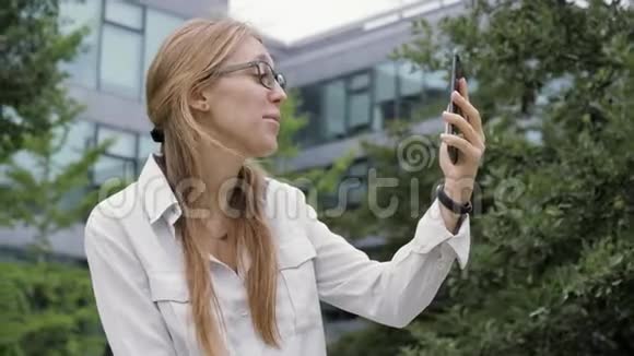 戴眼镜的聪明女孩用智能手机打视频电话视频的预览图