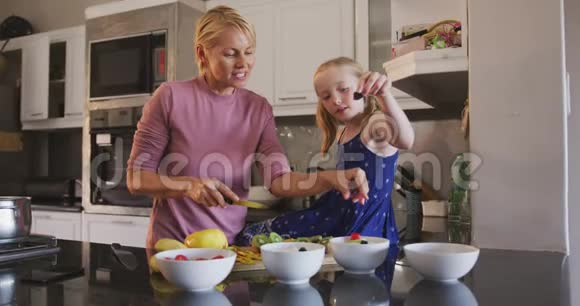 白种人妇女与女儿在家做饭的侧视图视频的预览图