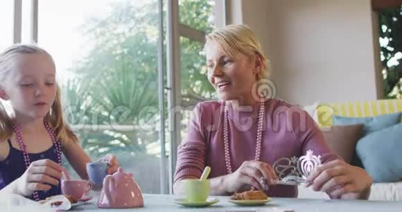 白种人女人在家里和女儿玩耍的侧视视频的预览图