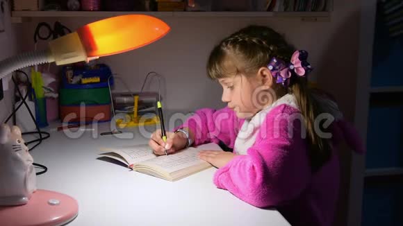 在台灯的灯光下一个女孩在深夜做作业视频的预览图