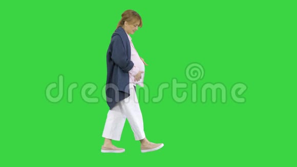 美丽微笑的孕妇走在绿色的屏幕上铬钥匙视频的预览图