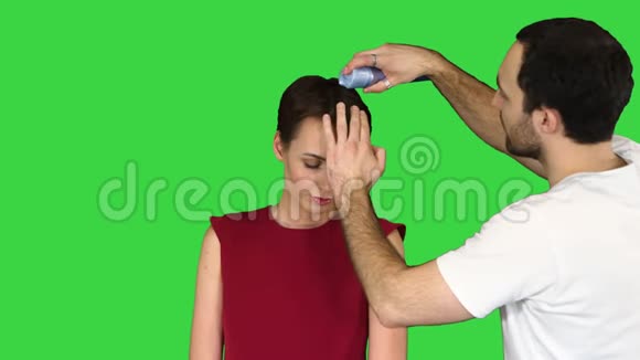 美丽发型和人的概念年轻妇女与理发师与头发喷雾在绿色屏幕色度键视频的预览图