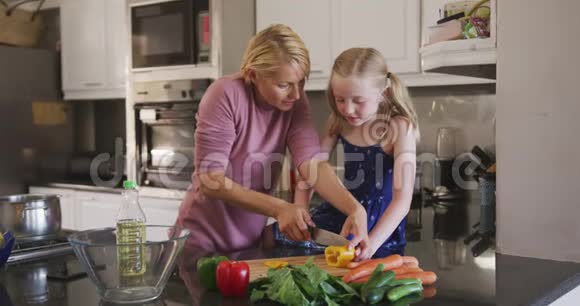 白种人妇女与女儿在家做饭的正面景色视频的预览图