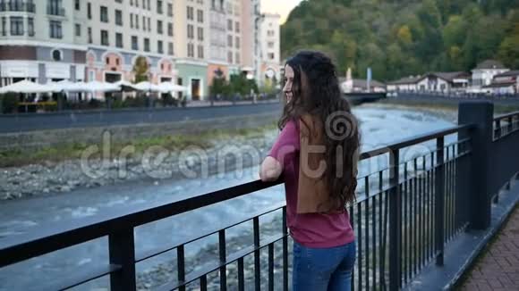 美丽的年轻女子在城市的河流长廊上欣赏美丽的风景视频的预览图