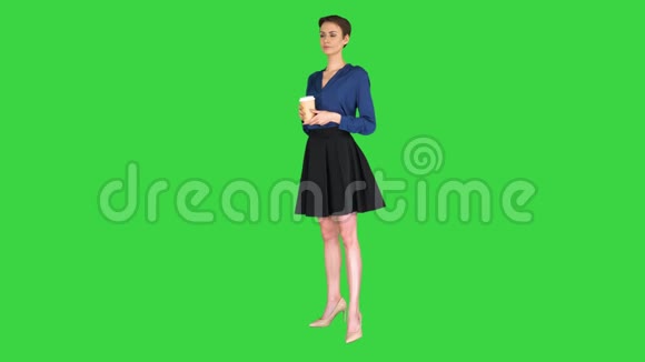 漂亮的女人拿着纸拿走杯子热饮料黑咖啡在绿色屏幕上Chroma键视频的预览图