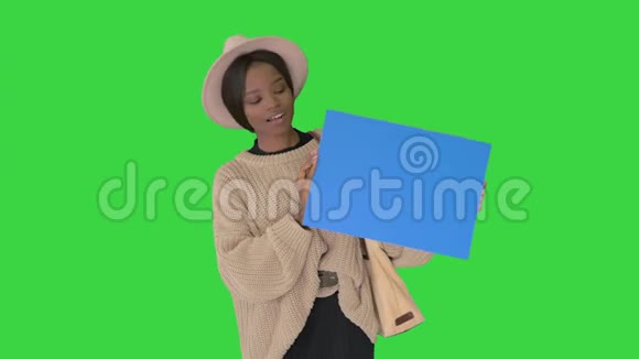 漂亮的年轻非洲裔美国女性展示和指向空白板上的绿色屏幕Chroma键视频的预览图