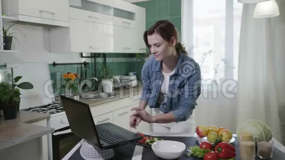 有吸引力的女性家庭主妇饮食准备素食沙拉新鲜蔬菜根据视频食谱视频的预览图