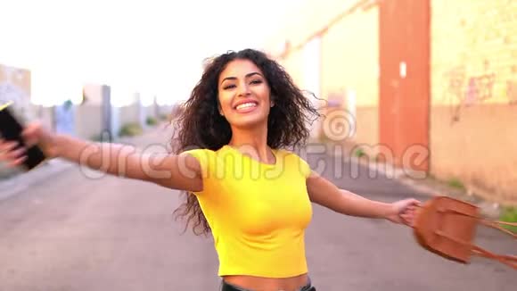 微笑着年轻的阿拉伯女人张开双臂走来走去视频的预览图