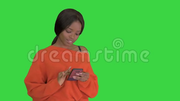美丽的非洲妇女使用智能手机技术应用程序在绿色屏幕Chroma键视频的预览图