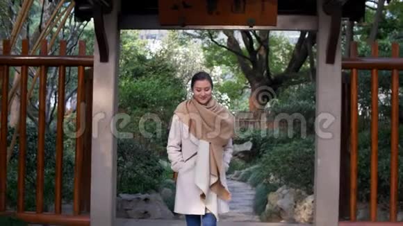 魅力四射的年轻混合女走过中国风格的盖茨和斯迈尔斯4k视频的预览图