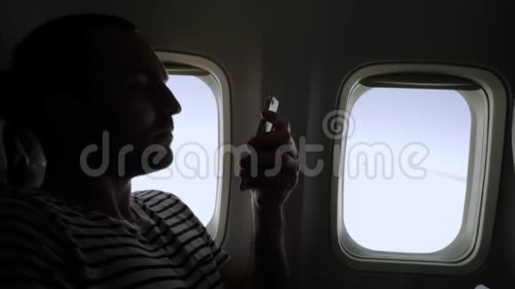 坐在飞机上看手机照片的人视频的预览图