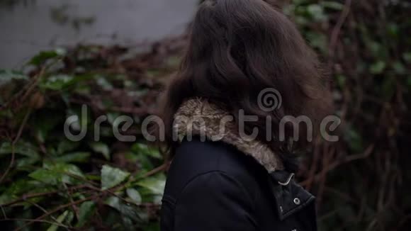 在寒冷的日子外美丽的混搭女孩在她的头发上缓慢地活动视频的预览图