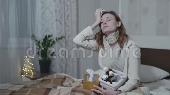 生病的女孩因感冒或流感咳嗽而喉咙痛用餐巾纸盖住嘴用浸在温暖的药视频的预览图