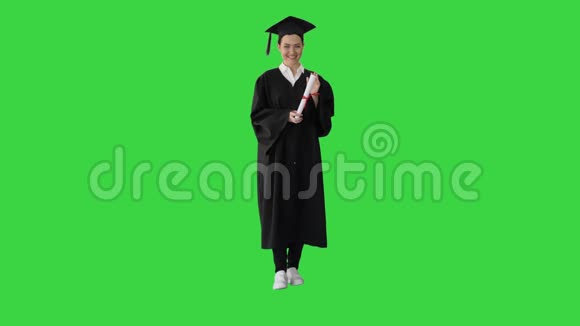 美丽的年轻女子毕业生正看着相机微笑在一个绿色的屏幕色度键视频的预览图
