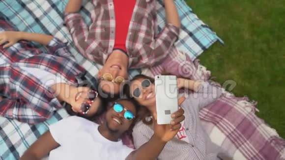 快乐的朋友躺在地毯上为社交媒体或朋友流媒体视频的预览图