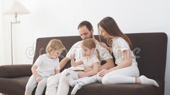 一个穿着轻便衣服的年轻成熟家庭的肖像一起在沙发上度过快乐时光视频的预览图