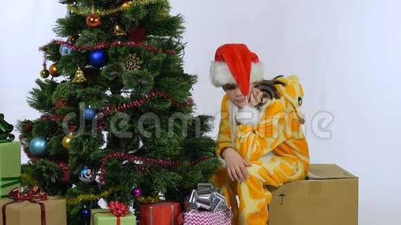 新年过后女孩坐在圣诞树附近的一个盒子思念视频的预览图