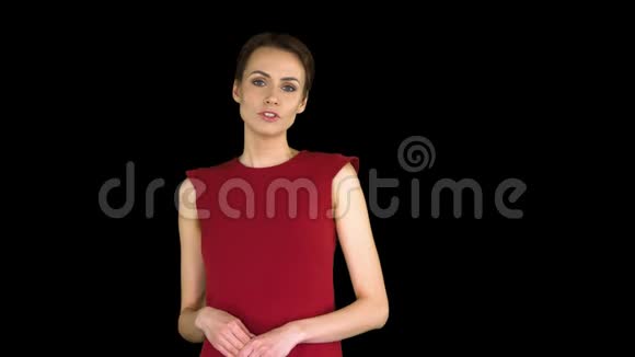 兴奋的美丽年轻女子穿着红色连衣裙与镜头交谈阿尔法频道视频的预览图