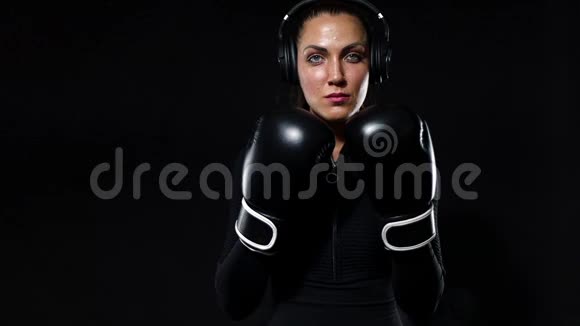 年轻女子运动员拳击手在健身房做拳击训练戴着手套穿着运动服的女孩视频的预览图