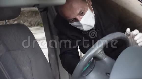中年男子用口罩手套清洁轮消毒汽车视频的预览图