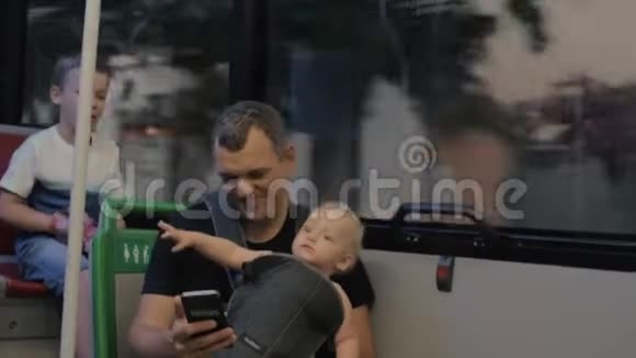 爸爸和两个孩子在公共汽车上视频的预览图