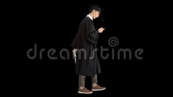 毕业典礼快乐的学生走路和发短信在他的电话阿尔法频道视频的预览图