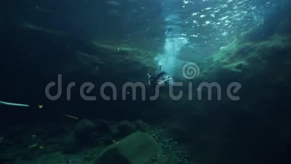 水下射击一个女人在清澈的瀑布下游泳视频的预览图