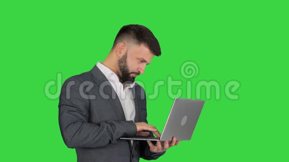 白人男子在笔记本电脑上打字站在绿色屏幕上Chroma键视频的预览图