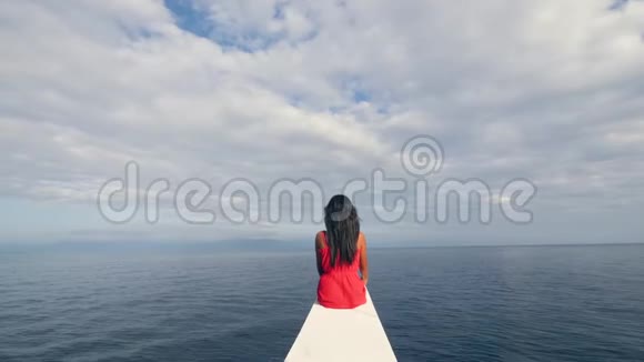 一个女人坐在帆船的边缘看着地平线视频的预览图
