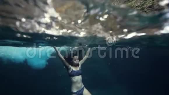 一个穿比基尼的瘦小女人漂浮在水下屏住呼吸视频的预览图