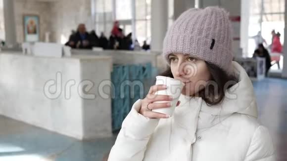 一位年轻女子喝着纸杯里的矿泉水视频的预览图