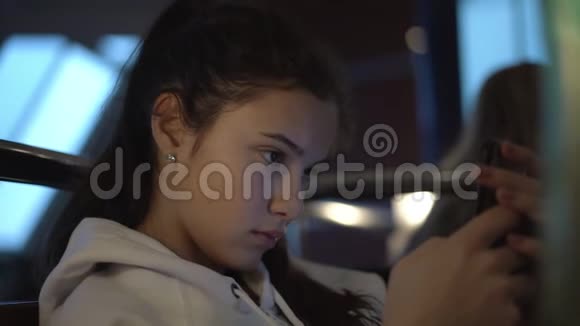 少女坐在渡轮餐厅使用智能手机视频的预览图