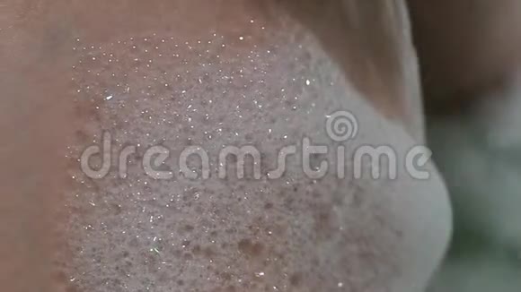 沐浴特写中女性身体上的肥皂泡沫视频的预览图