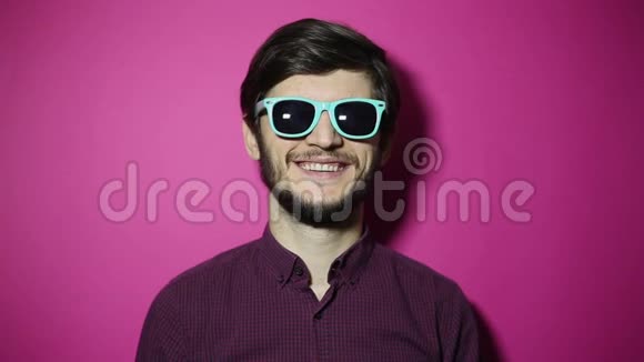 年轻快乐男人的肖像竖起大拇指孤立在粉红色的背景上视频的预览图