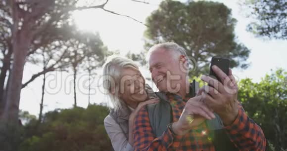 快乐的老夫妇在森林里拿着智能手机视频的预览图