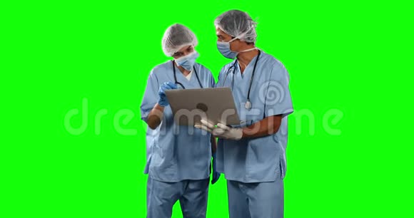 在带绿色屏幕的笔记本电脑上观看一些结果的医生的正面视图视频的预览图