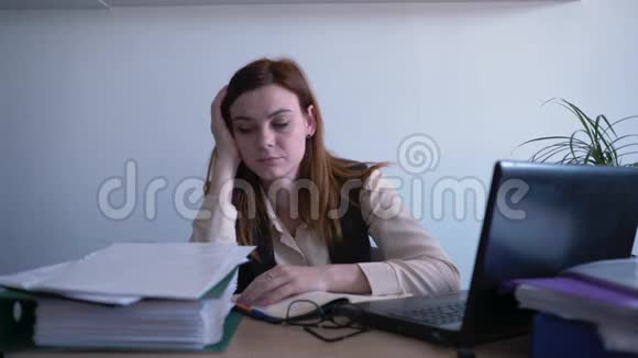 厌倦了工作沮丧的女员工在笔记本电脑上工作女商人厌倦了坐在办公室的许多报告视频的预览图