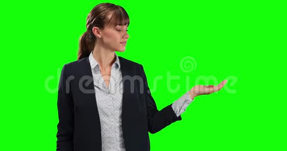 白种人女性的侧视图用绿色屏幕握住她的手进行复制空间视频的预览图