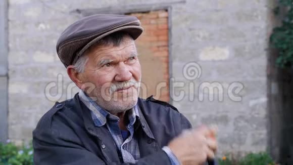 白发苍苍的老素食者留着胡子和鬃毛用破旧的蓝色夹克袖子清洗水果戴帽子的养老金领取者视频的预览图