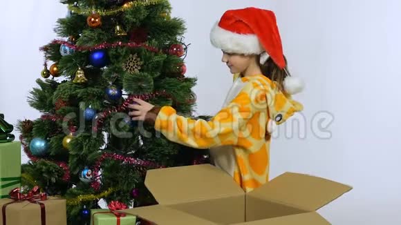 一个女孩把圣诞树上的圣诞装饰品放进盒子里视频的预览图
