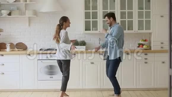 快乐的年轻浪漫情侣在厨房跳跳舞视频的预览图