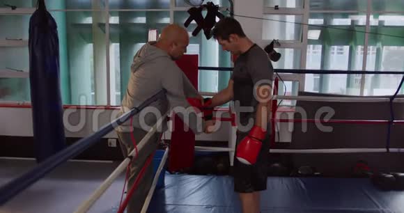 高加索教练在拳击场上包扎运动员双手视频的预览图