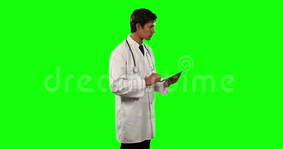 医生使用带有绿色屏幕的数字平板电脑的侧视图视频的预览图
