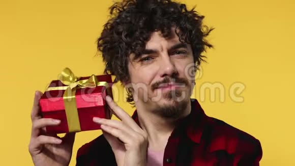 一个男人送一份红色的礼物给情人节或国际妇女节生日惊喜英俊快乐的欧洲男人视频的预览图