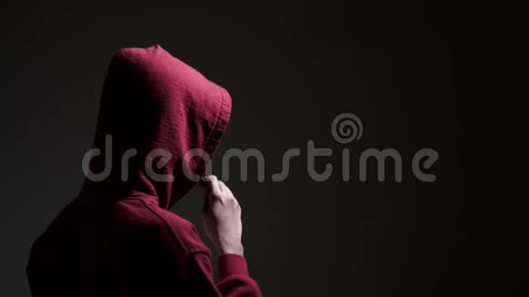 穿着红色连帽衫的年轻男性在黑暗的小巷里视频的预览图