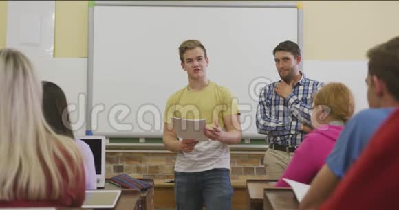 白人高中男孩向一群青少年展示视频的预览图