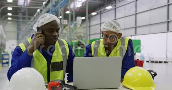 仓库工人在工厂使用笔记本电脑视频的预览图