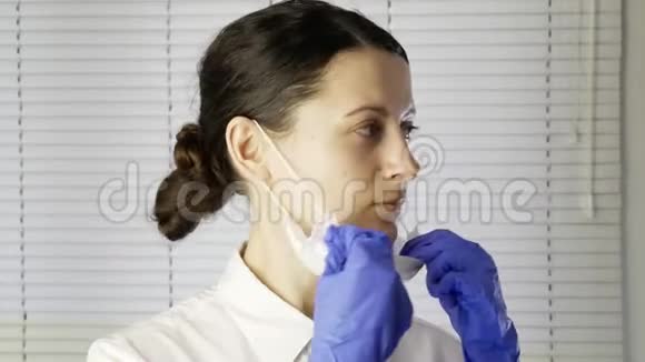 带手套的年轻女医生戴上医用口罩视频的预览图